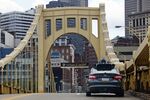 An autonomous vehicle crosses one of Pittsburgh's iconic bridges.