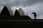 A pedestrian&nbsp;walks past the Sydney Opera House in Sydney, Australia.