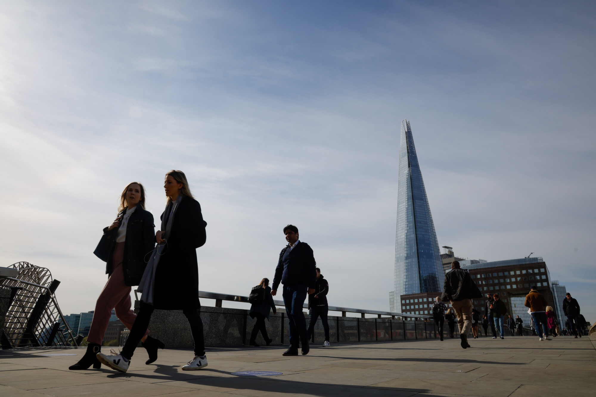 Commuters walk along London Bridge.