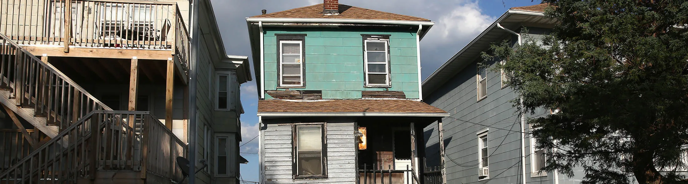 ATLANTIC CITY, NJ - AUGUST 26: Valencia Terrell looks to an abandoned foreclosed home on August 26, 2015 in Atlantic City, New Jersey. Terrell, worked in casino VIP services for years before her home was destroyed in Hurricane Sandy and she had to leave work to take care of family members. She now survives with the aid of food stamps and takes her family members to a soup kitchen for additional meals. After years of decline in Atlantic City, in 2014 some 8,000 people were layed-off when four of the city's major casinos closed, bringing Atlantic City's unemployment rate to more than 11 percent, double the national average. As unemployment assistance has begun to expire for many people, shelters like the Atlantic City Rescue Mission have seen a large jump in need. They serve upwards of 700 meals and house some 300 people a day, including many families. The mass unemployment has produced the highest foreclosure rate of any metropolitan U.S. area, with 1 out of 113 homes now in foreclosure in Atlantic County.
