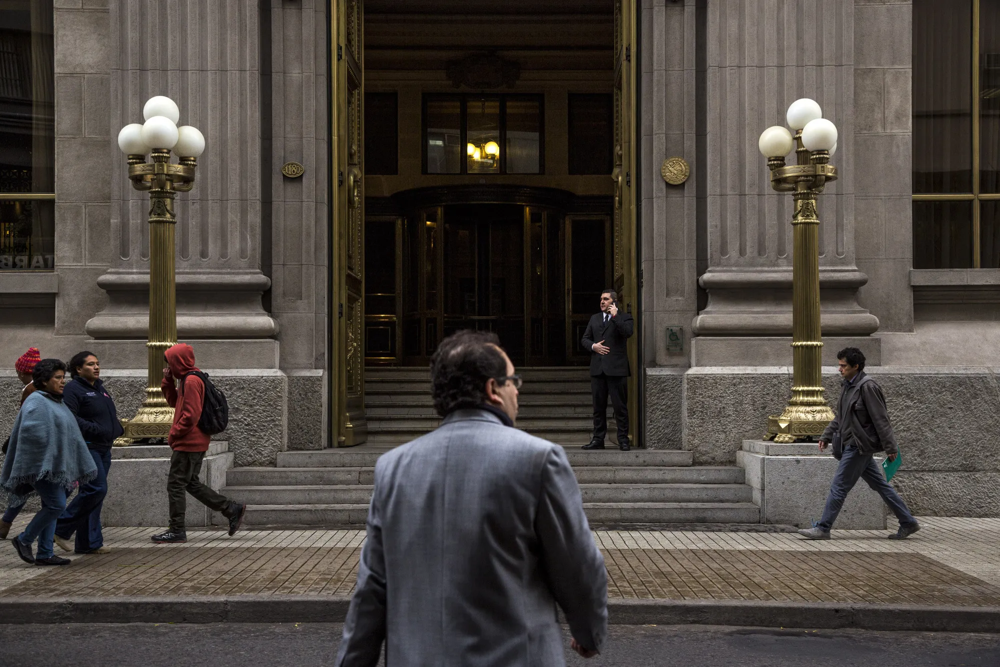 Pedestrians pass in front of the Central Bank of Chile in downtown Santiago, Chile.