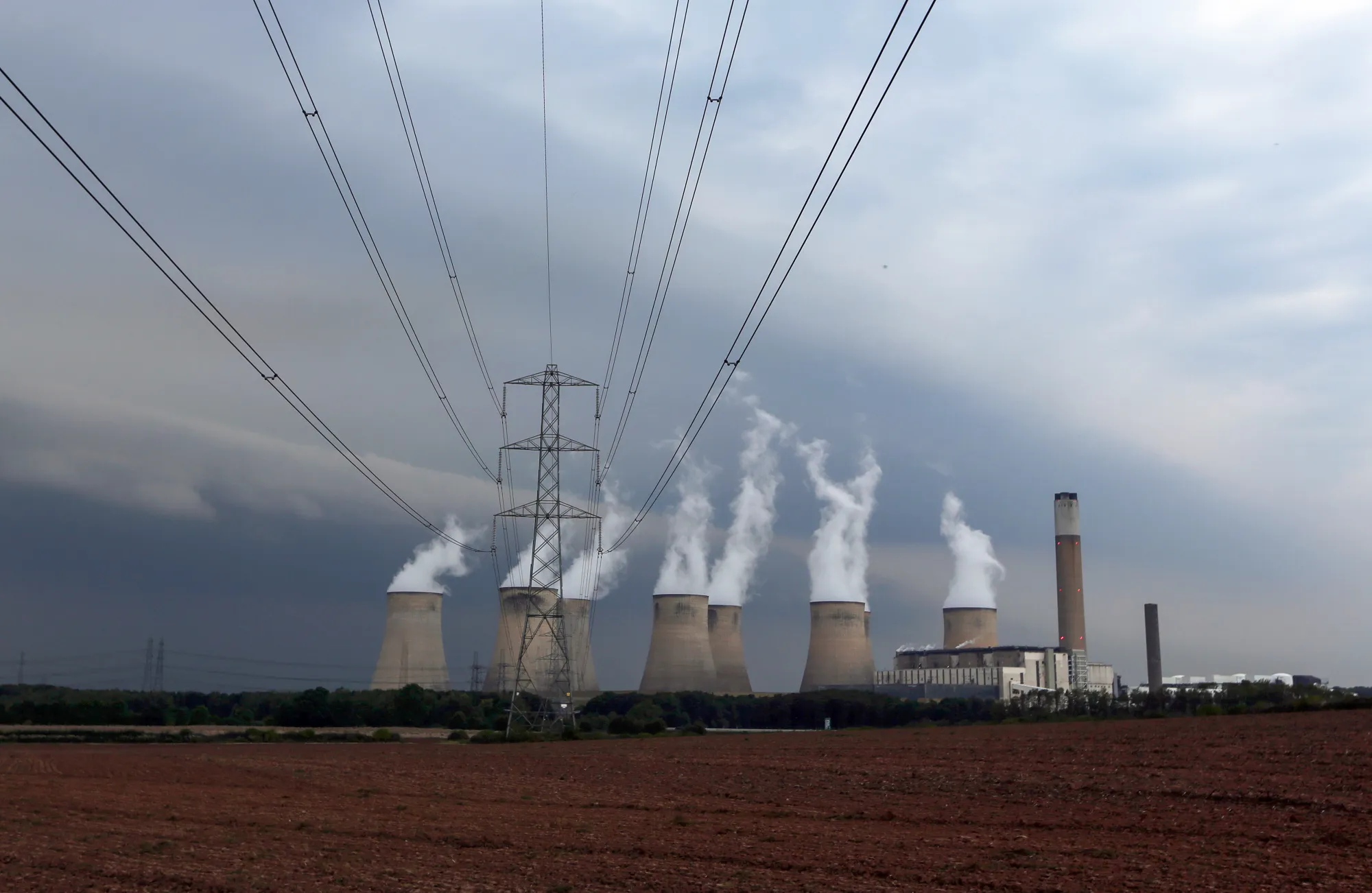 Electricity pylons stand near to the cooling towers at a coal-fired power station in Ratcliffe-on-Soar.