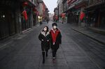 A couple walk on a nearly empty and shuttered commercial street in Beijing on Feb. 12.