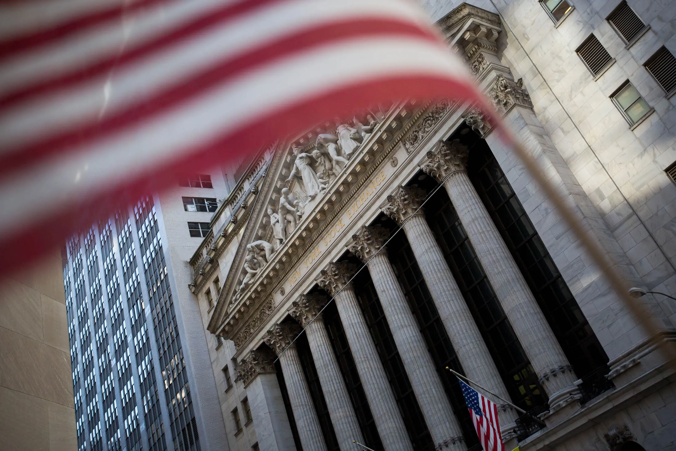 American flags fly outside the New York Stock Exchange (NYSE) in New York, U.S., on Friday, Nov. 4, 2016. U.S. stocks fluctuated amid payrolls data that bolstered speculation the economy is strong enough to weather higher interest rates, while investors remained wary before the looming presidential election.
