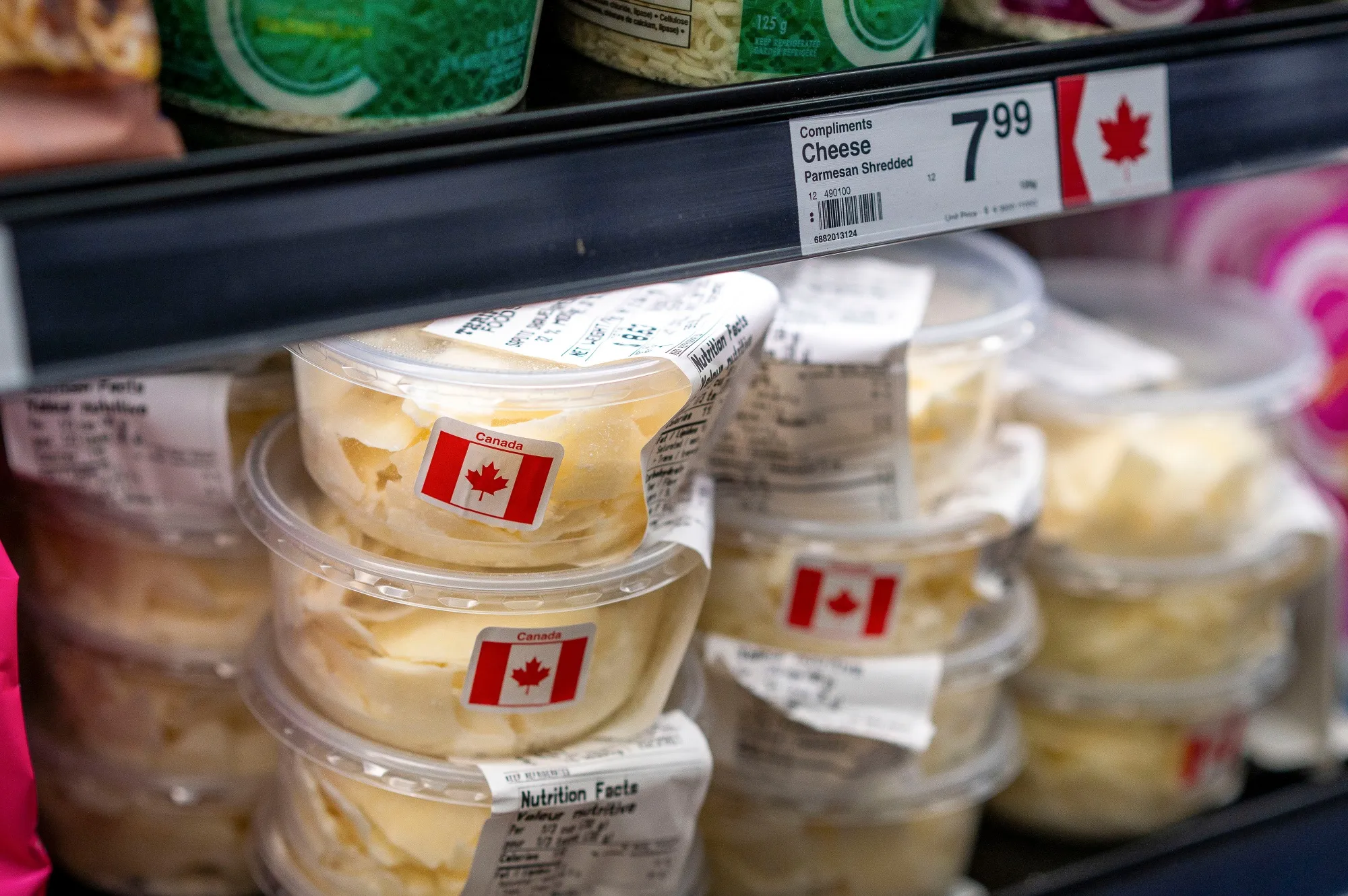 Canadian flag stickers on cheese containers at a grocery store in Sidney, British Columbia.