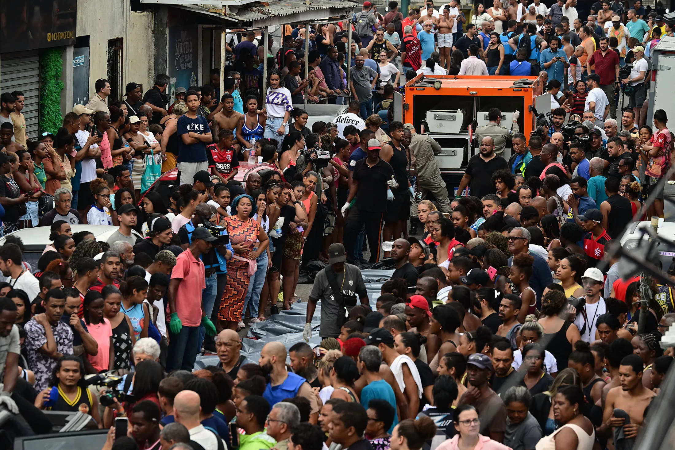 Residents stand next to bodies on Sao Lucas Square in the Vila Cruzeiro favela, following the police operation in Rio de Janeiro on Oct. 29.
