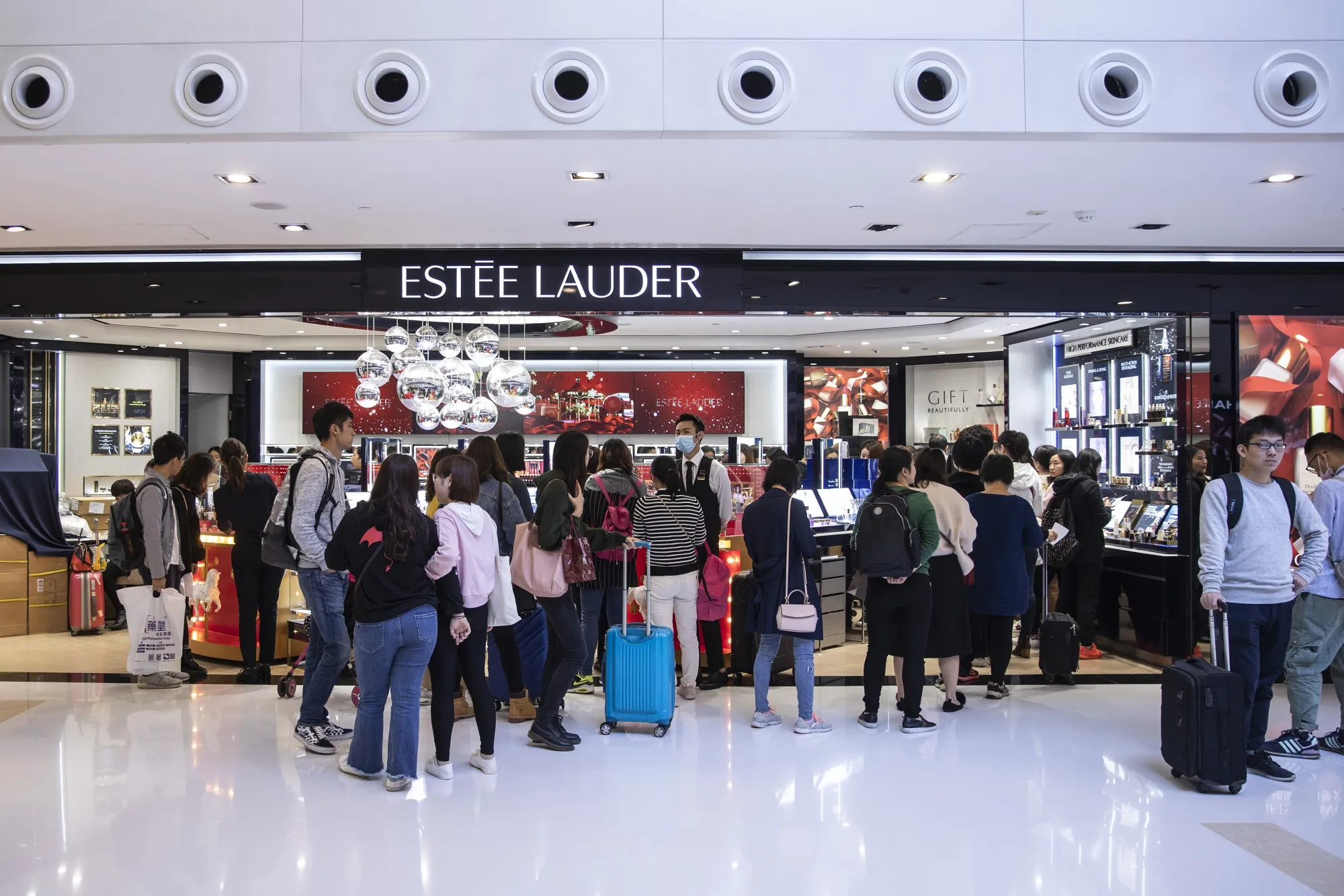 Shoppers stand in line outside an Estee Lauder&nbsp;store inside New Town Plaza shopping mall, operated by Sun Hung Kai Properties Ltd., in Hong Kong.