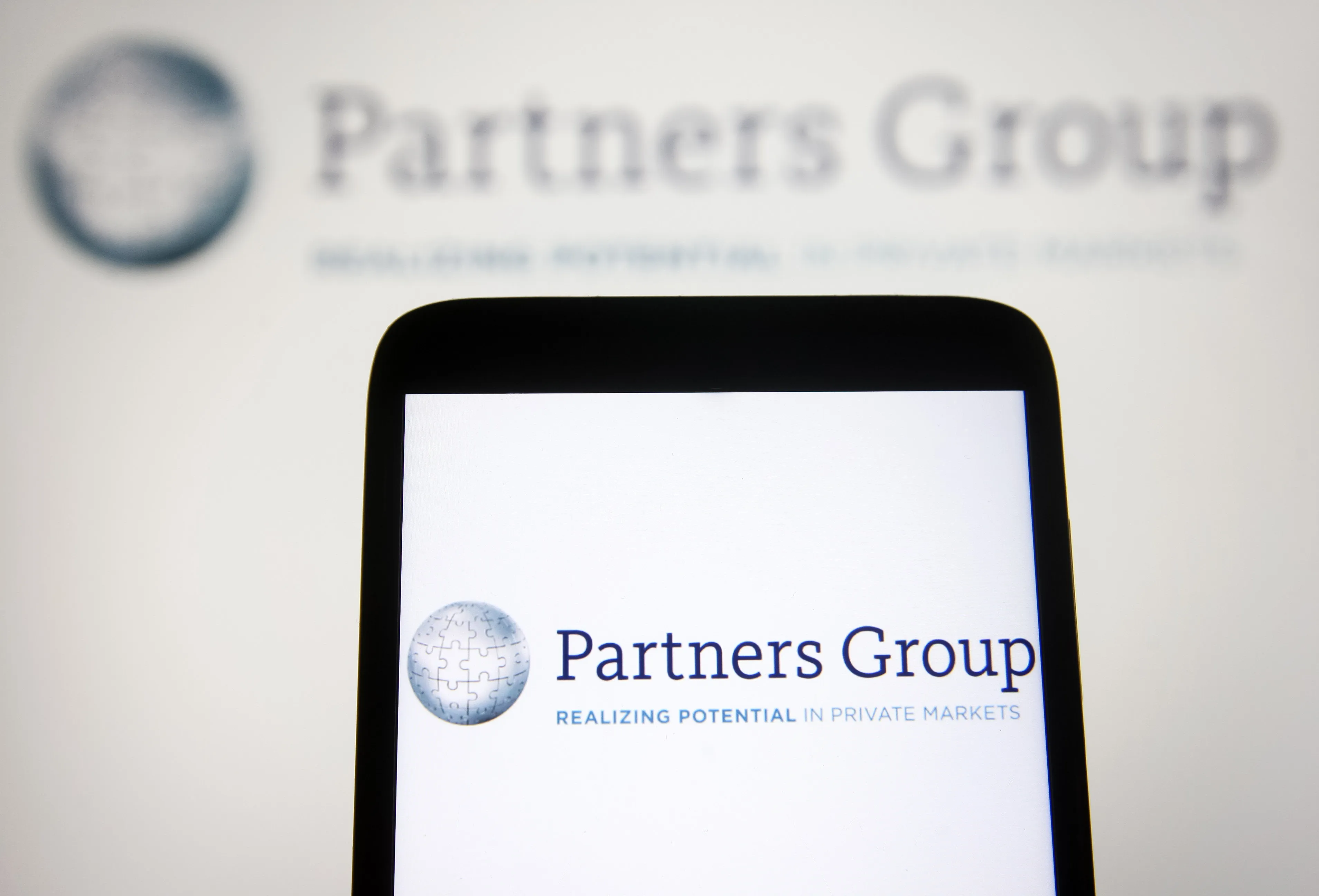 In this photo illustration a Partners Group Holding AG logo