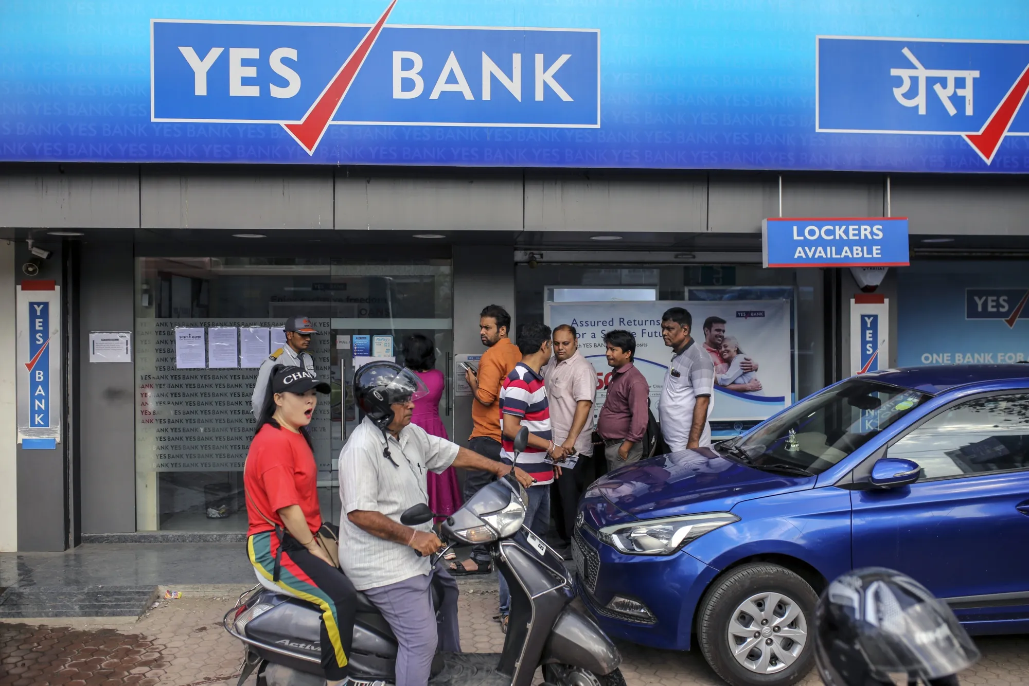 Customers stand in line outside a Yes Bank Ltd. branch in Mumbai.