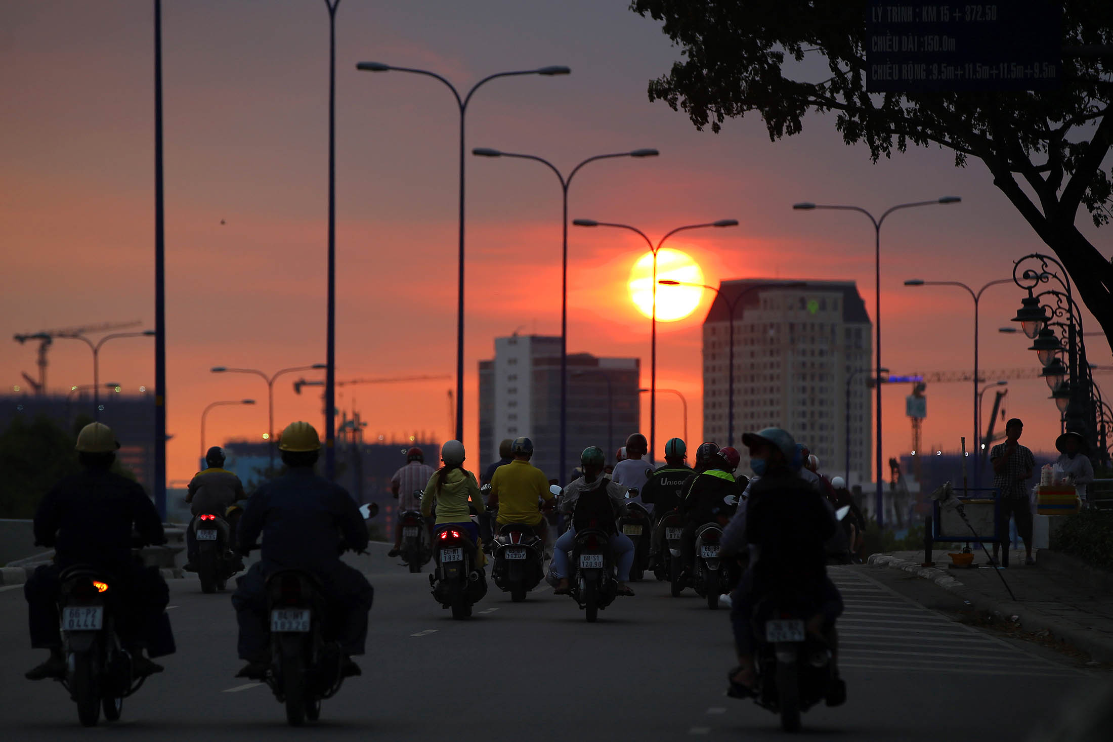 Motorcyclists travel along a road during sunset in Ho Chi Minh City, Vietnam, on Tuesday, Jan. 10, 2017. Vietnam's economy expanded more than 6 percent for a second year in 2016, defying a regional slowdown to remain one of the world's best performers as retails sales rose 10.2 percent.
