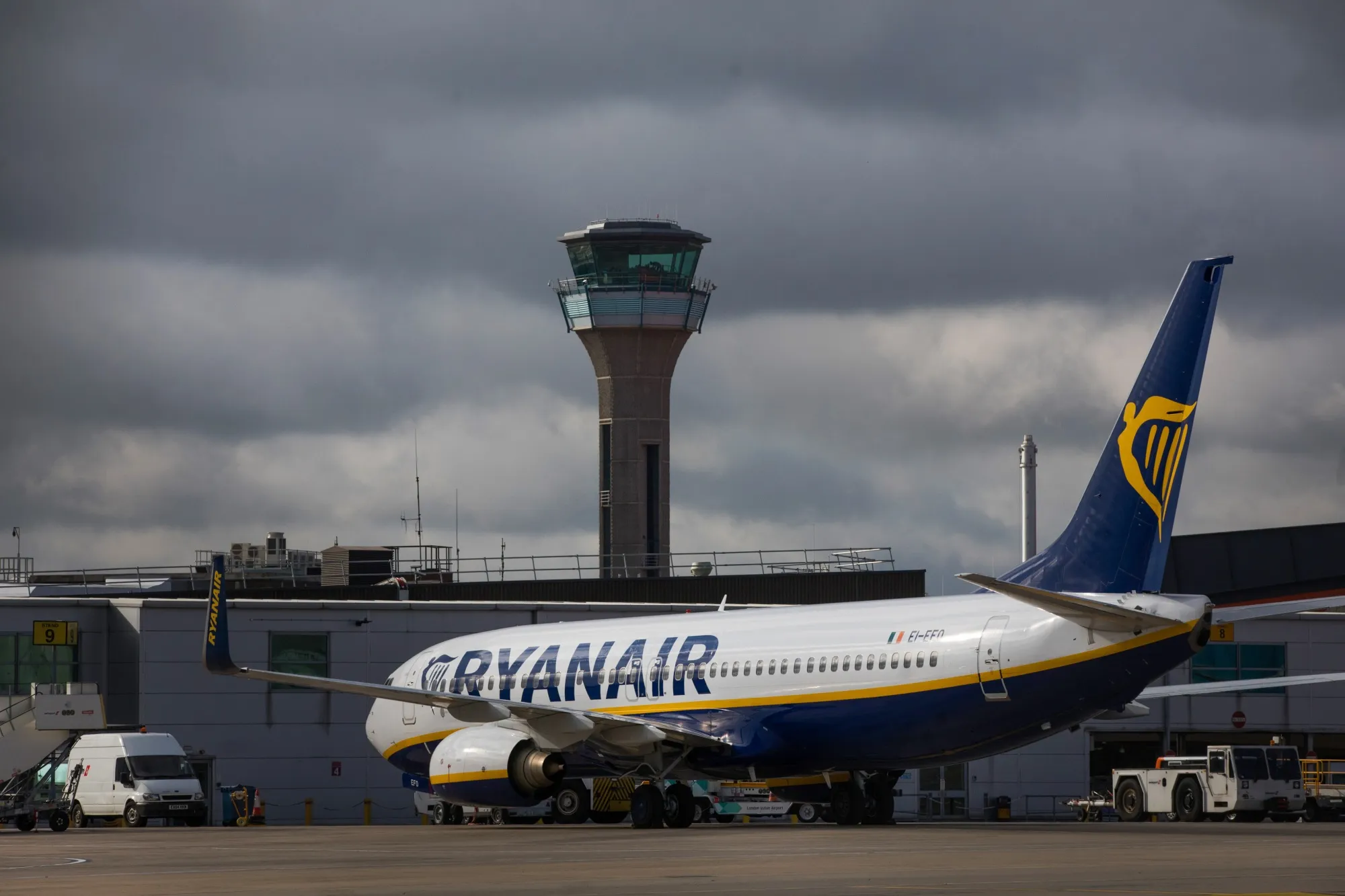A passenger aircraft, operated by Ryanair Holdings Plc, stands on the tarmac at London Luton Airport in Luton.