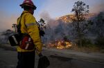 A firefighter watches as the Sheep Fire burns in Wrightwood, Calif., Sunday, June 12, 2022. (AP Photo/Ringo H.W. Chiu)