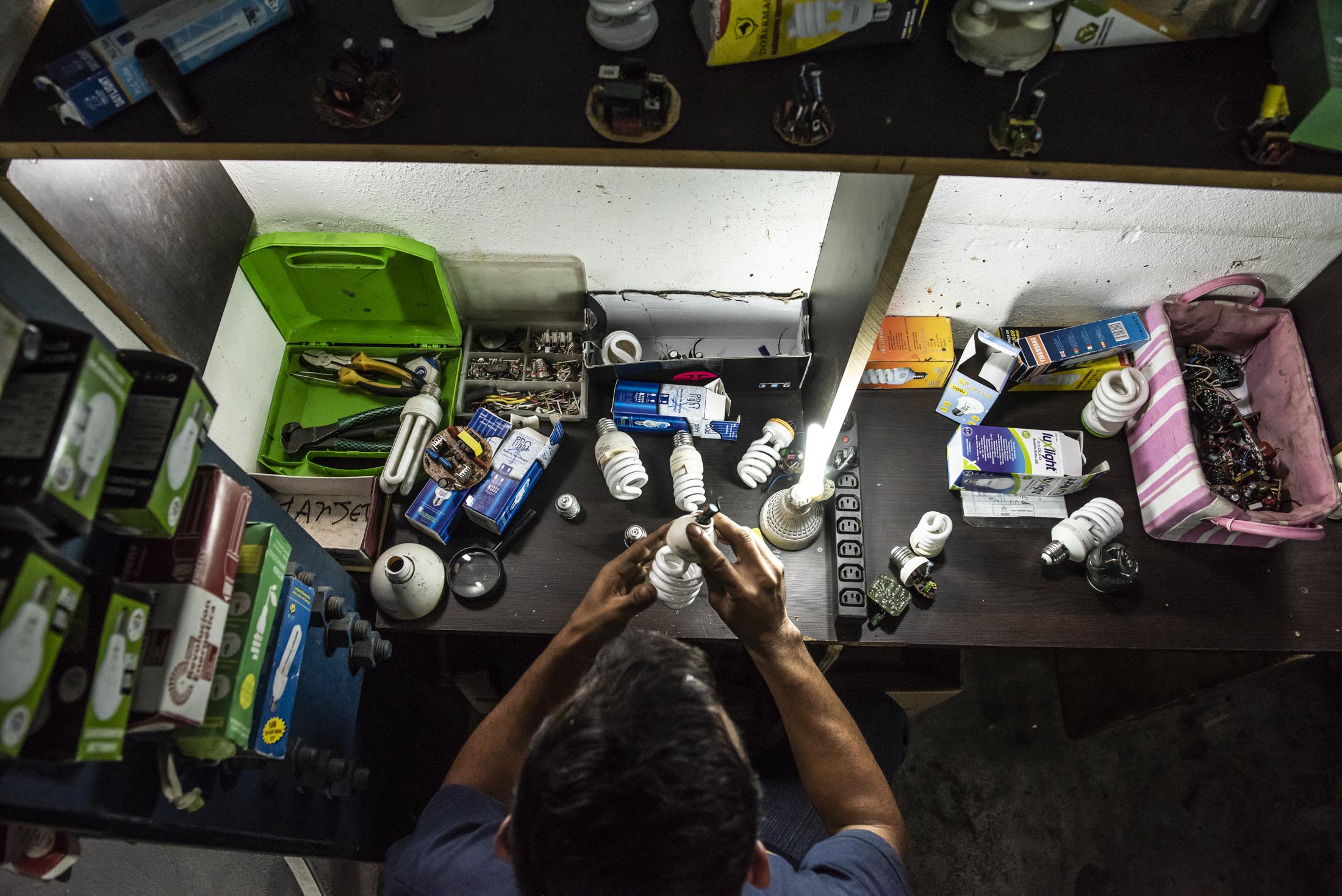 Jose Ramirez, a lifelong tinkerer, practices his new craft: repairing lightbulbs.