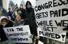 Government workers and their supporters hold signs during a protest in Boston.