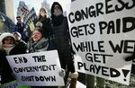 Government workers and their supporters hold signs during a protest in Boston.
