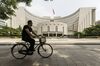 A man rides a bicycle past the People's Bank of China (PBOC) headquarters in Beijing, China, on Friday, June 7, 2019. China's central bank governor said there's "tremendous" room to adjust monetary policy if the trade war deepens, joining counterparts in Europe and the U.S. in displaying readiness to act to support the economy.