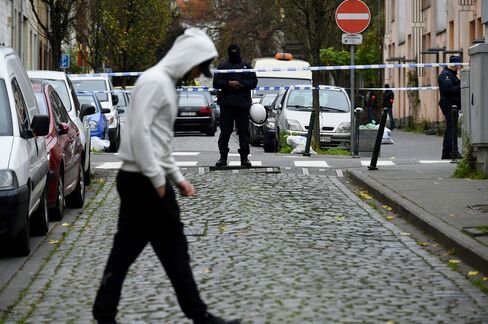 Police officers man a cordon as an operation takes place in the Molenbeek district of Brussels on Nov. 16, 2015.