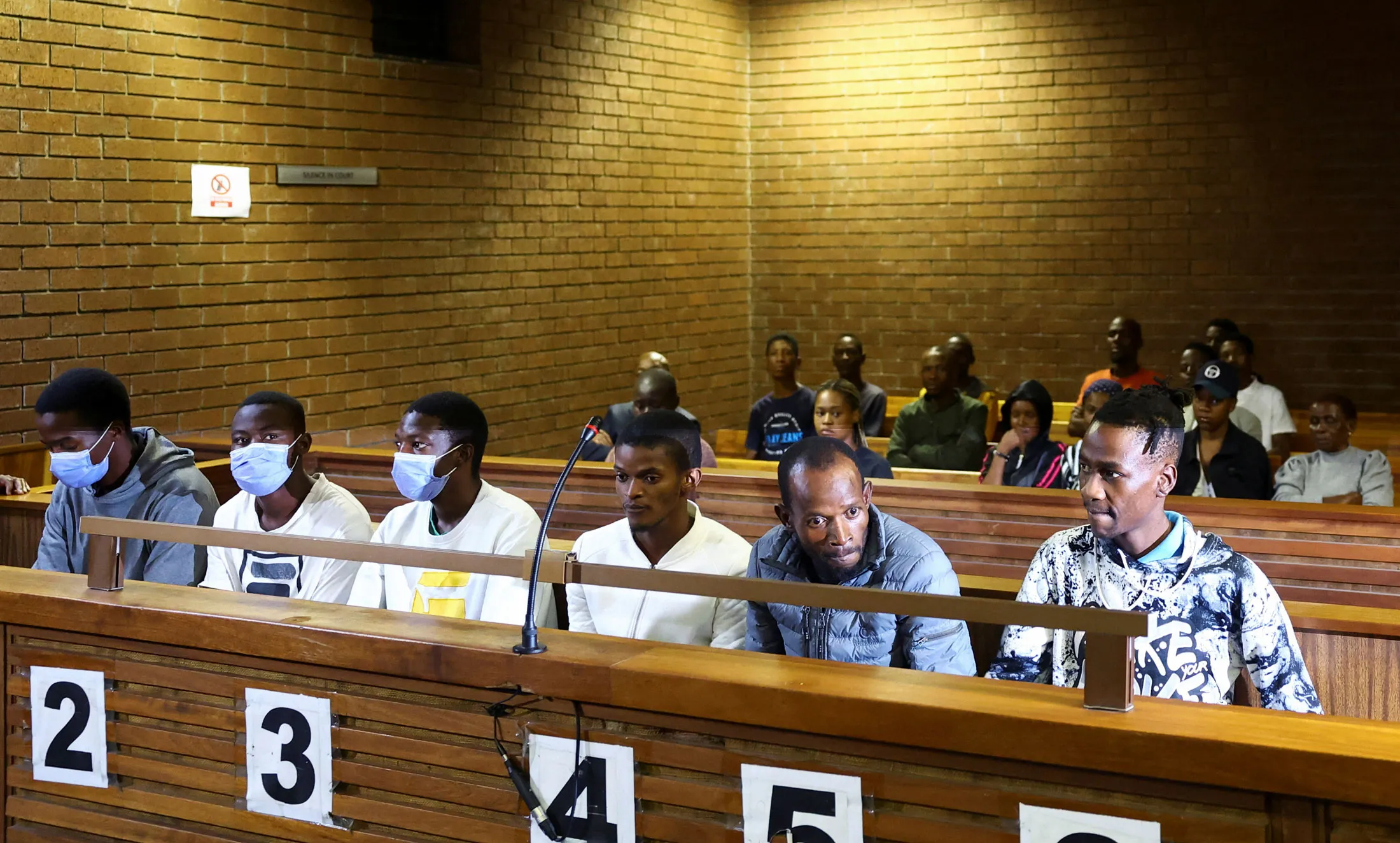 Six men accused of murdering Kaizer Chiefs soccer player Luke Fleurs sit at a court appearance outside Johannesburg on April 25.