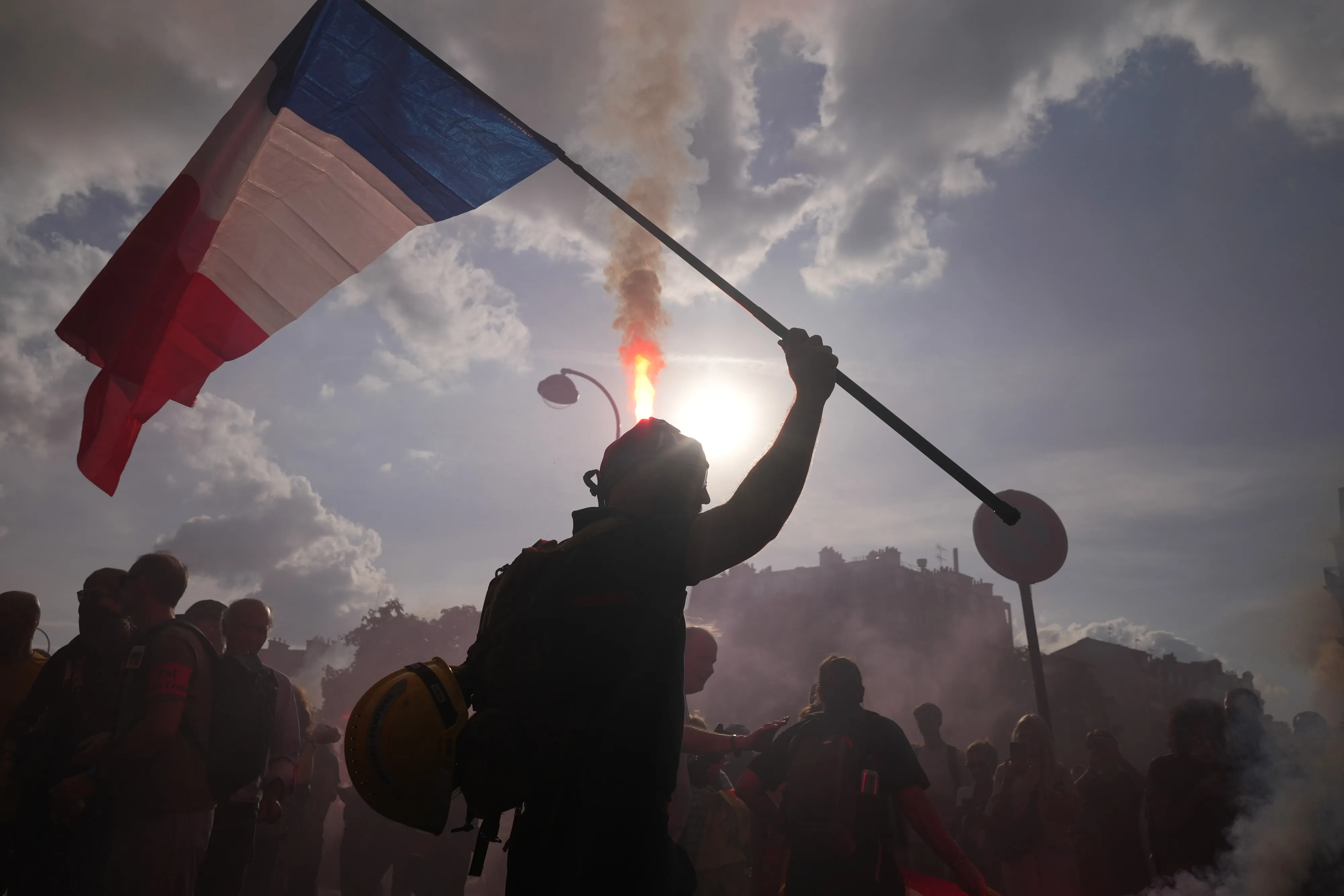 A protester raises a national flag during a demonstration against the government's draft budget in Paris on Sept. 29.