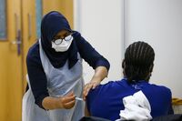 A visitor receives a dose of the AstraZeneca Plc Covid-19 vaccine in London, U.K., on March 19. 