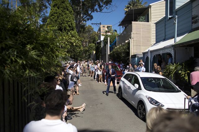 An auctioneer, center, takes a bid during an auction of a residential property in the Paddington suburb of Sydney, Australia, on Saturday, Feb. 20, 2021. Australia's housing market is booming again, with the biggest monthly price gain in 17 years dispelling fears of a Covid-induced downturn.