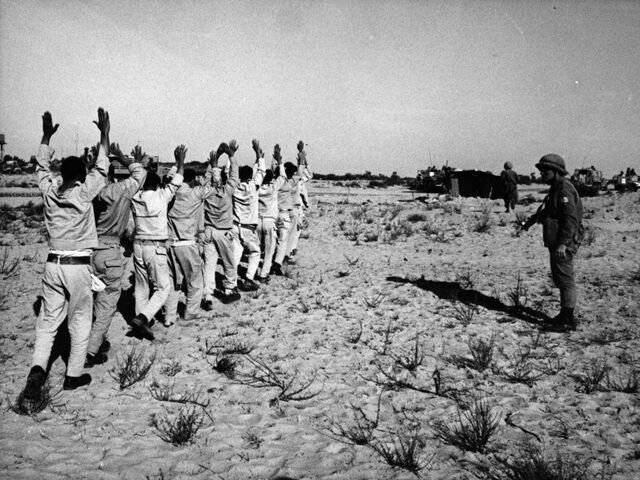Egyptian prisoners of war holding their hands aloft after being rounded up by Israeli forces in the Sinai desert following the Six-Day War.