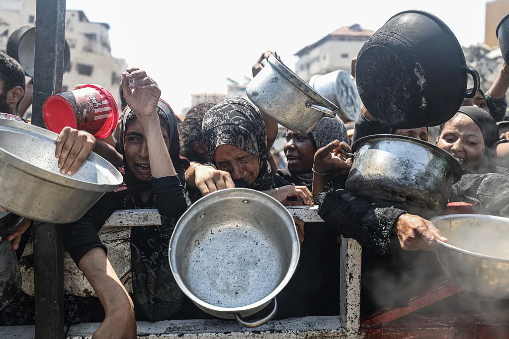 Palestinians gather to receive food distributed by a charity organization in Gaza City.