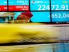 Pedestrians wearing face masks stand in front of an electric quotation board displaying the numbers of the Nikkei 225 Index on the Tokyo Stock Exchange in Tokyo on June 11, 2020. (Photo by Philip FONG / AFP) (Photo by PHILIP FONG/AFP via Getty Images)