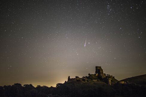 A meteor flashes across the night sky in Corfe Castle, United Kingdom.