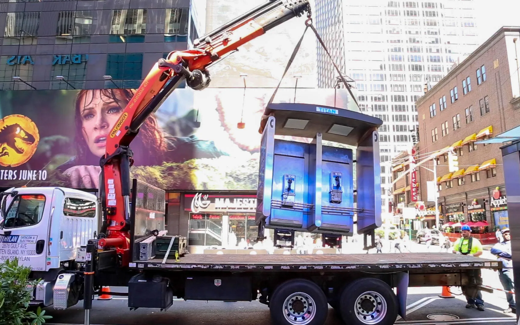 The city’s last double phone booth gets hoisted away on Monday.&nbsp;