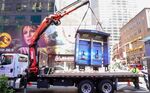 The city’s last double phone booth gets hoisted away on Monday.&nbsp;