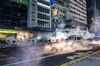 A police vehicle is shrouded in a cloud of tear gas during a protest on Nathan Road in the Mong Kok district of Hong Kong, China, on Sunday, Oct. 20, 2019. Hong Kong protesters set off fires and vandalized subway stations, banks and stores as another weekend of demonstrations descended into destruction and violence.