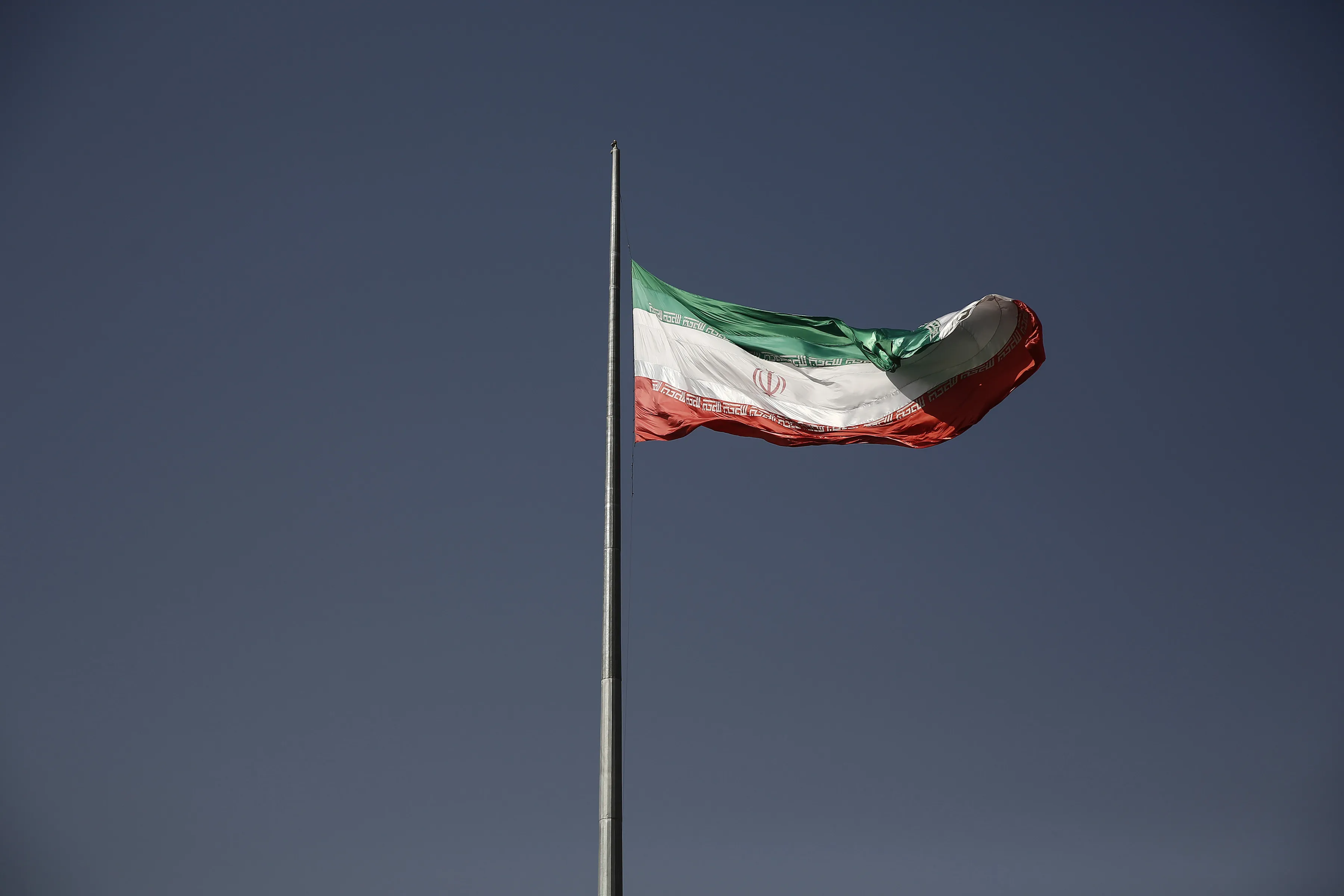 An Iranian national flag flies from a flagpole in a residential district of Tehran, Iran