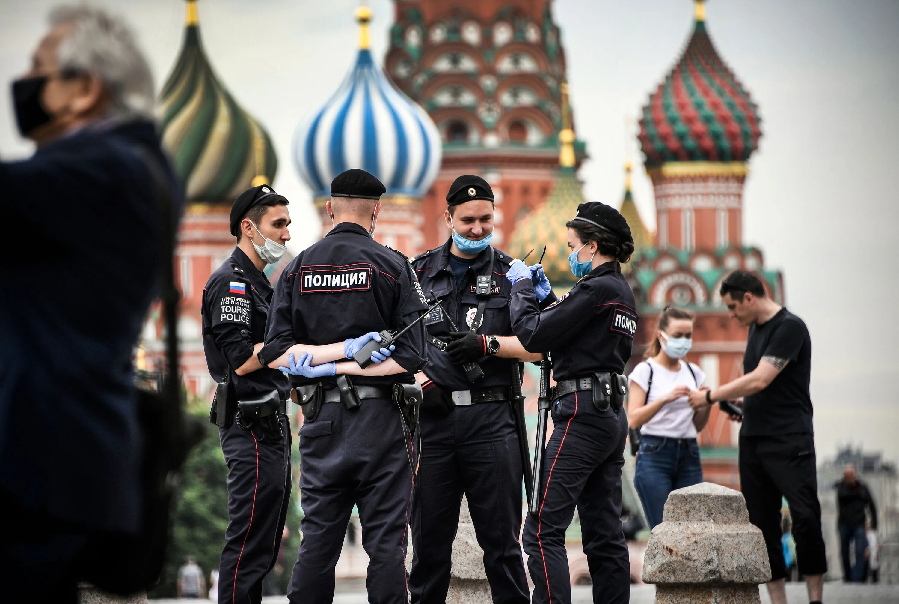 Police officers wearing face masks and gloves patrol at Red Square in Moscow.