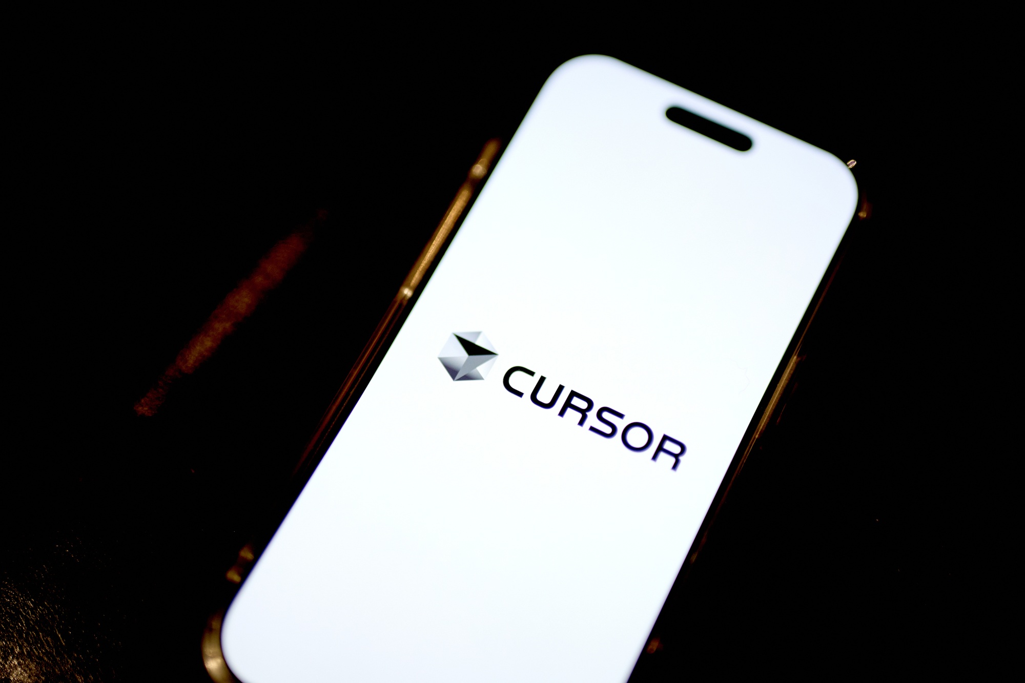 The Cursor logo on a smartphone.