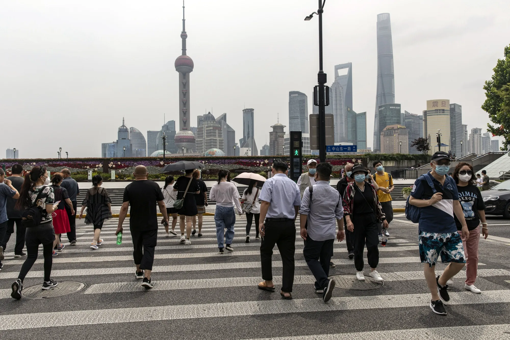 Pedestrians near the Bund in Shanghai on Wednesday. China's financial capital reported its fewest Covid-19 cases in almost three months as residents celebrated a significant easing of curbs on movement.