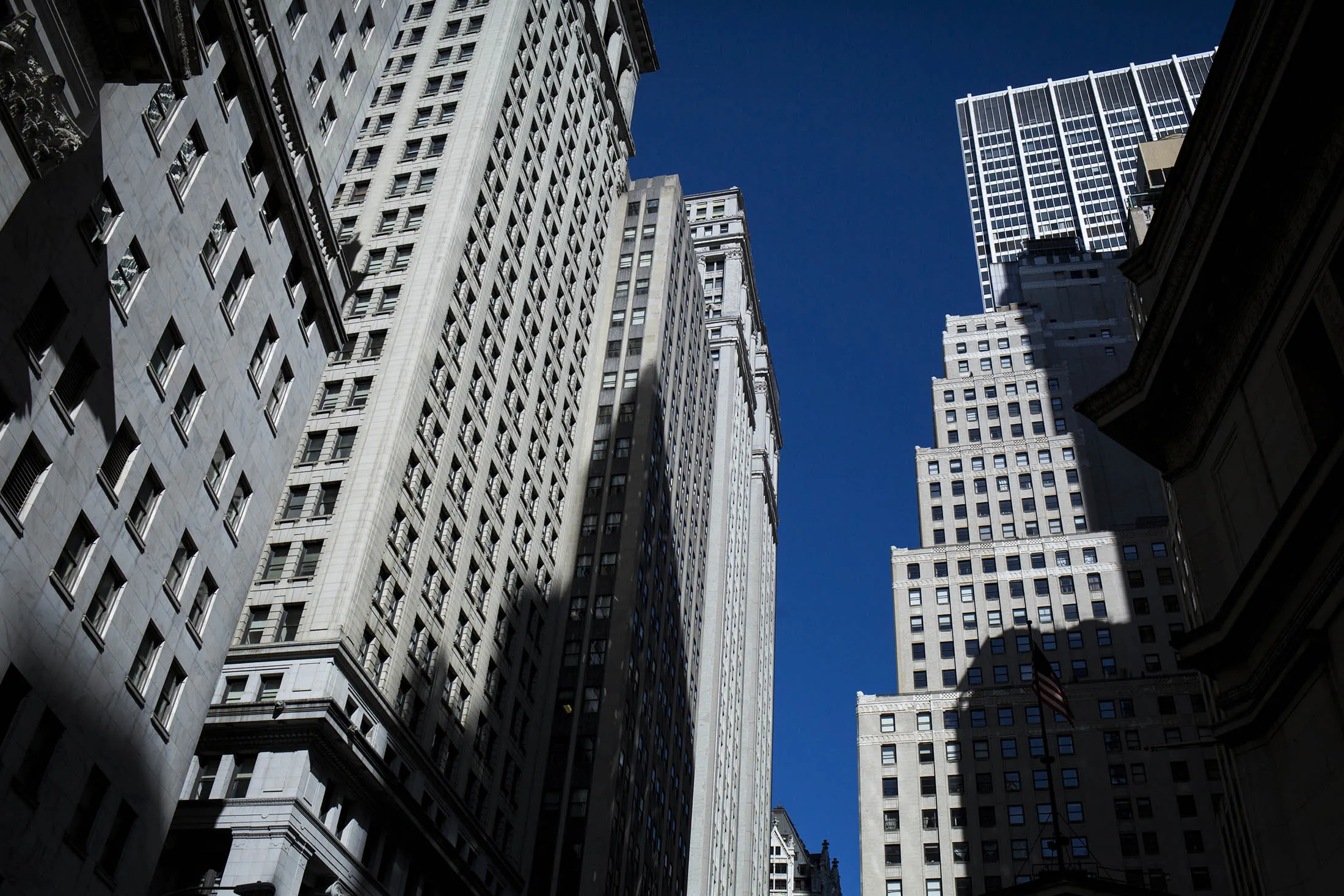 Buildings stand on Wall Street near the New York Stock Exchange (NYSE) in New York, U.S., on Monday, Feb. 22, 2016. Stocks retreated with government bonds, while the euro rallied to the highest level in almost a month as investors looked past an unprecedented boost from European monetary policy to focus on rising anxiety that policymakers have lost the ability to jumpstart global growth and stave off deflation.
