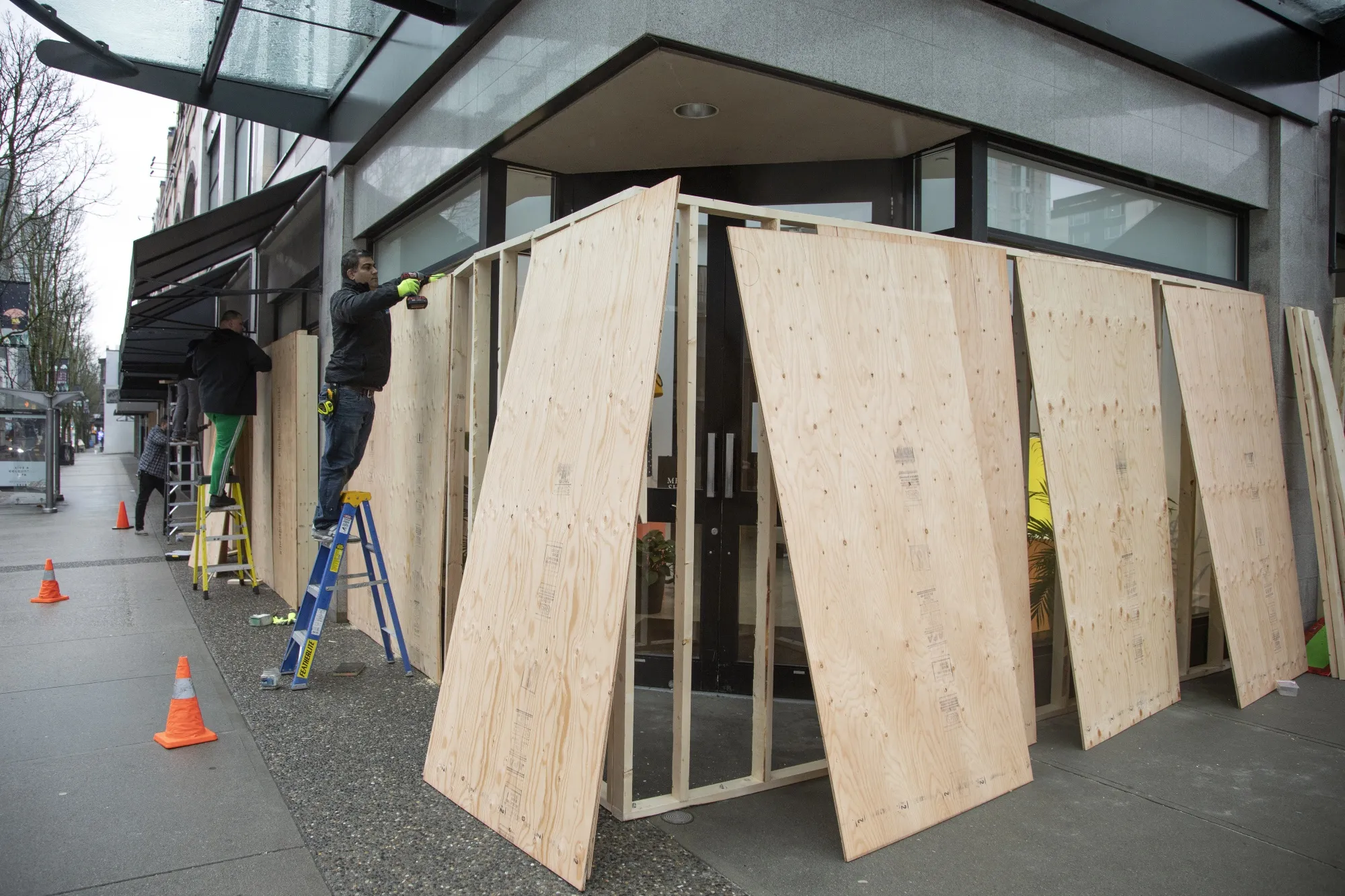 Workers board up a&nbsp;store&nbsp;in Vancouver on March 27.