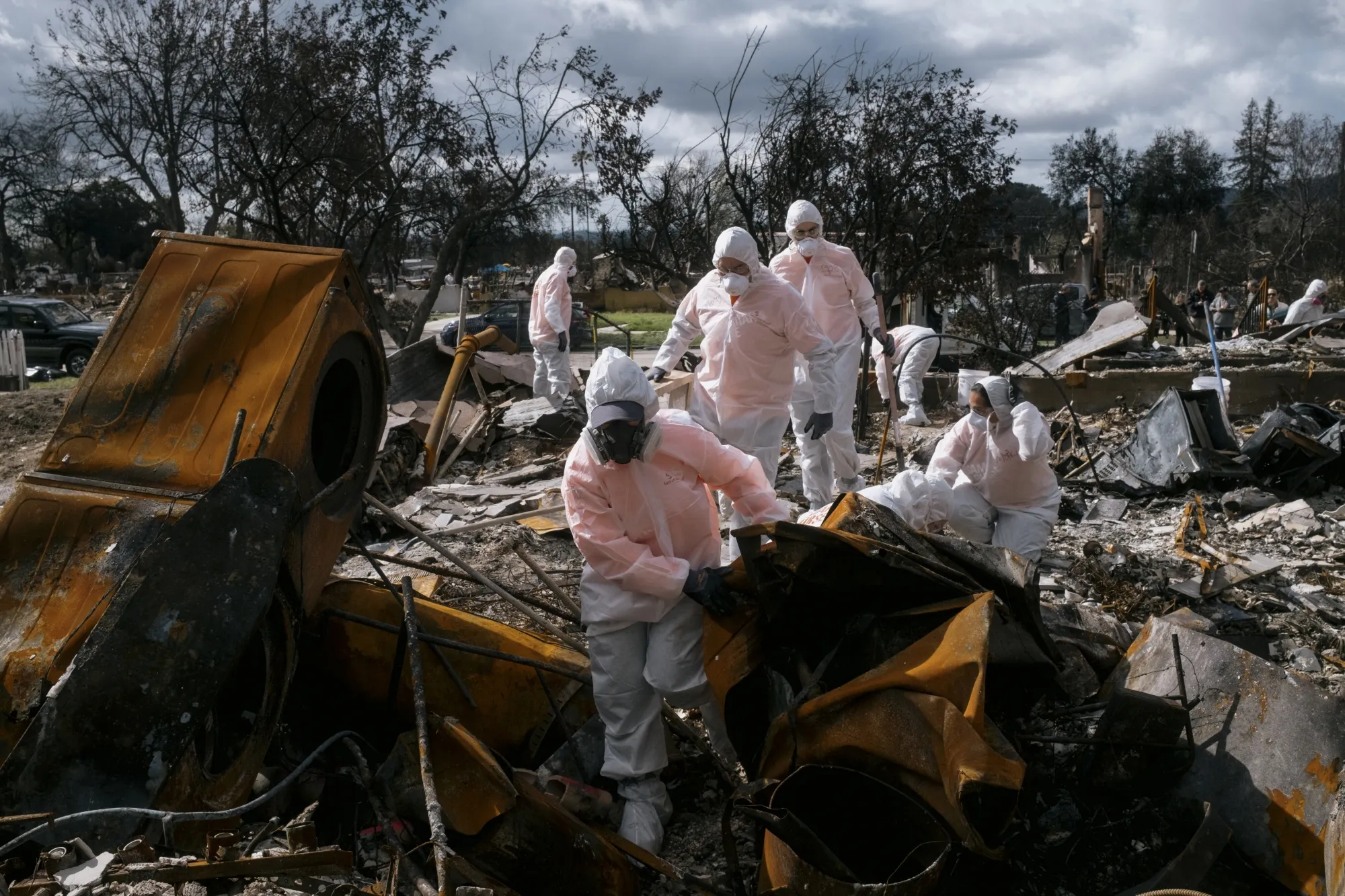 Volunteers search for personal belongings at a home destroyed in the Eaton Fire in Altadena, California.