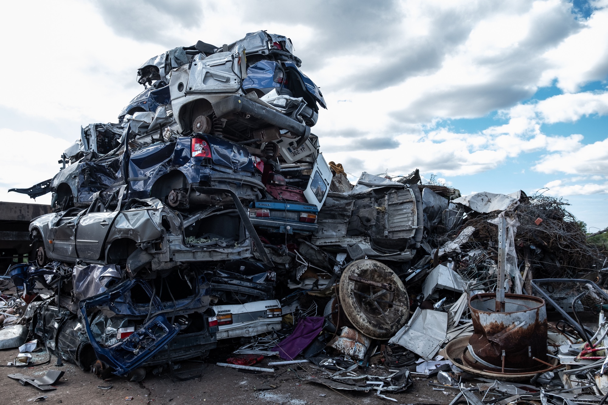 A pile of crushed cars sit at a vehicle scrapyard in France.
