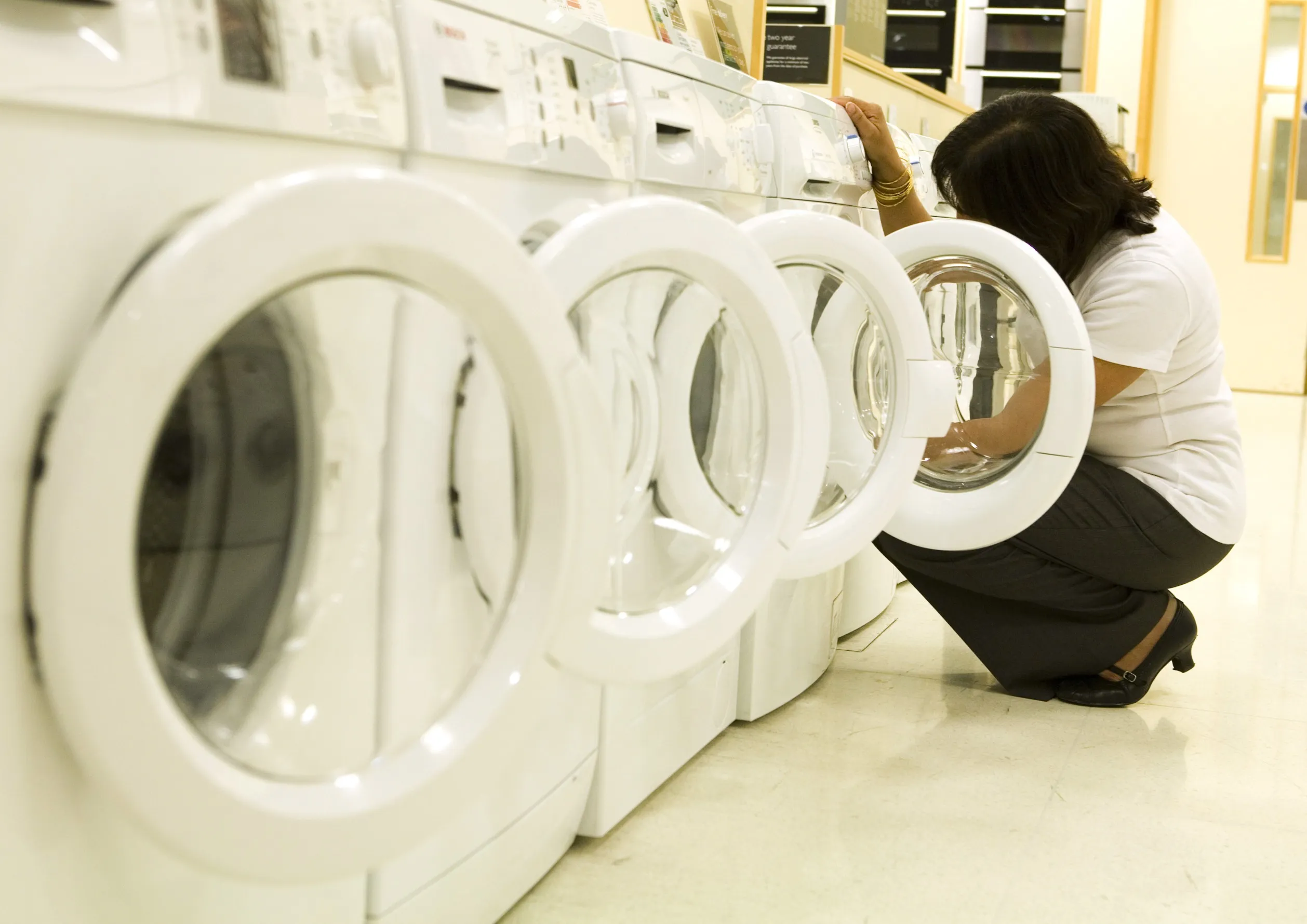 A customer inspects a washing machine at a John Lewis department store at Bluewater shopping centre in Kent, U. K.