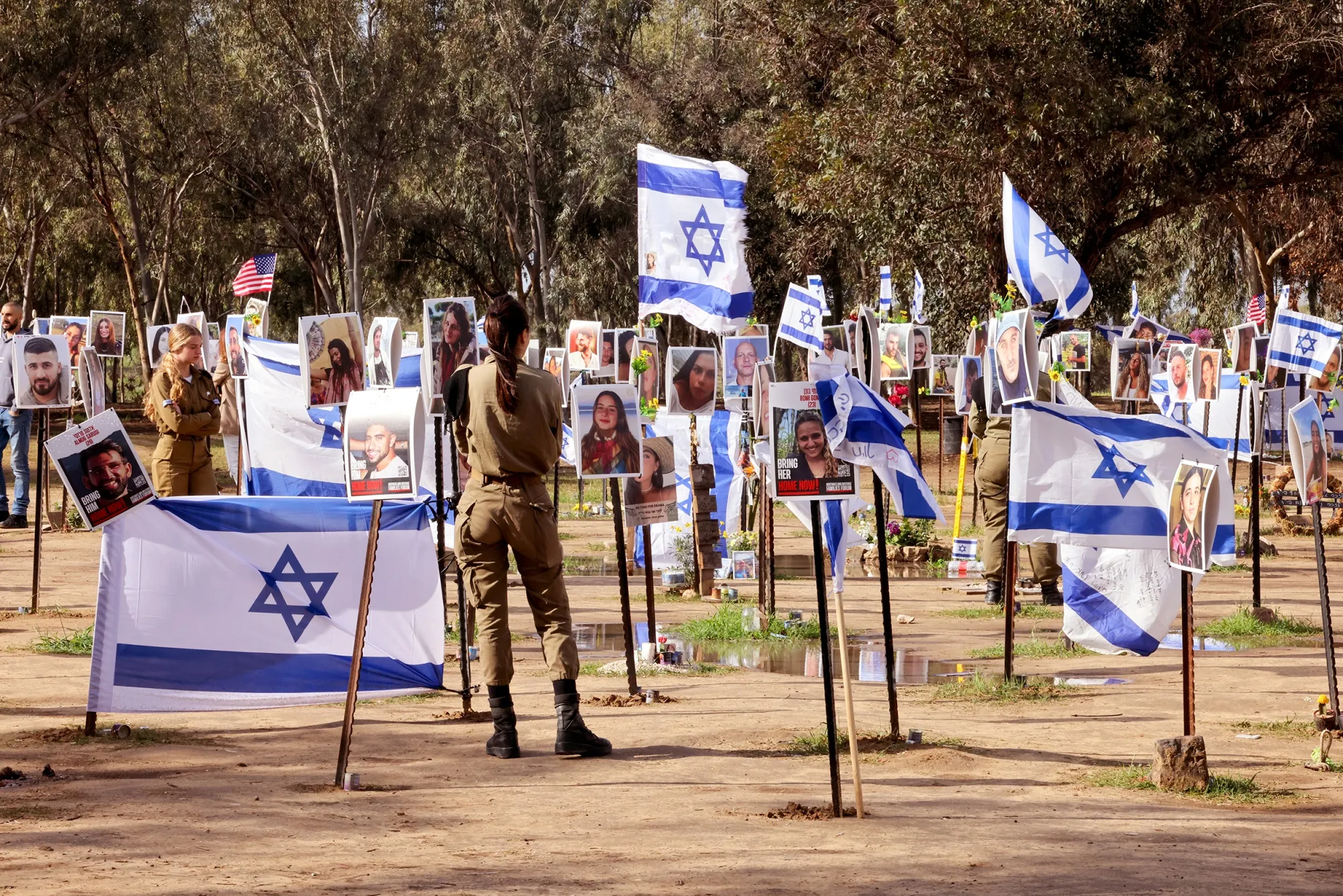 Israeli soldiers walk among portraits of those killed or kidnapped by Hamas militants at the Oct. 7 music festival near the Gaza border.