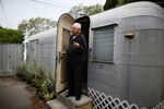An elderly man stands in the doorway of his mobile home in suburban Los Angeles. 