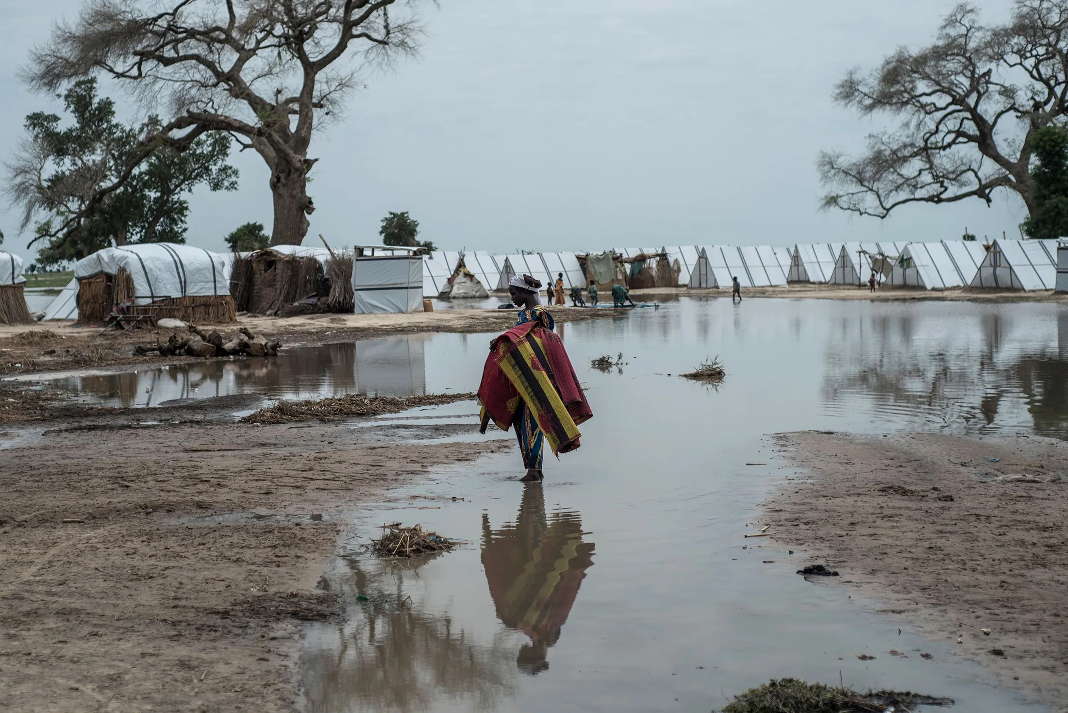 A woman stands in a pool of rain water at a camp in Rann,&nbsp;Nigeria&nbsp;on July 29, 2017.&nbsp;