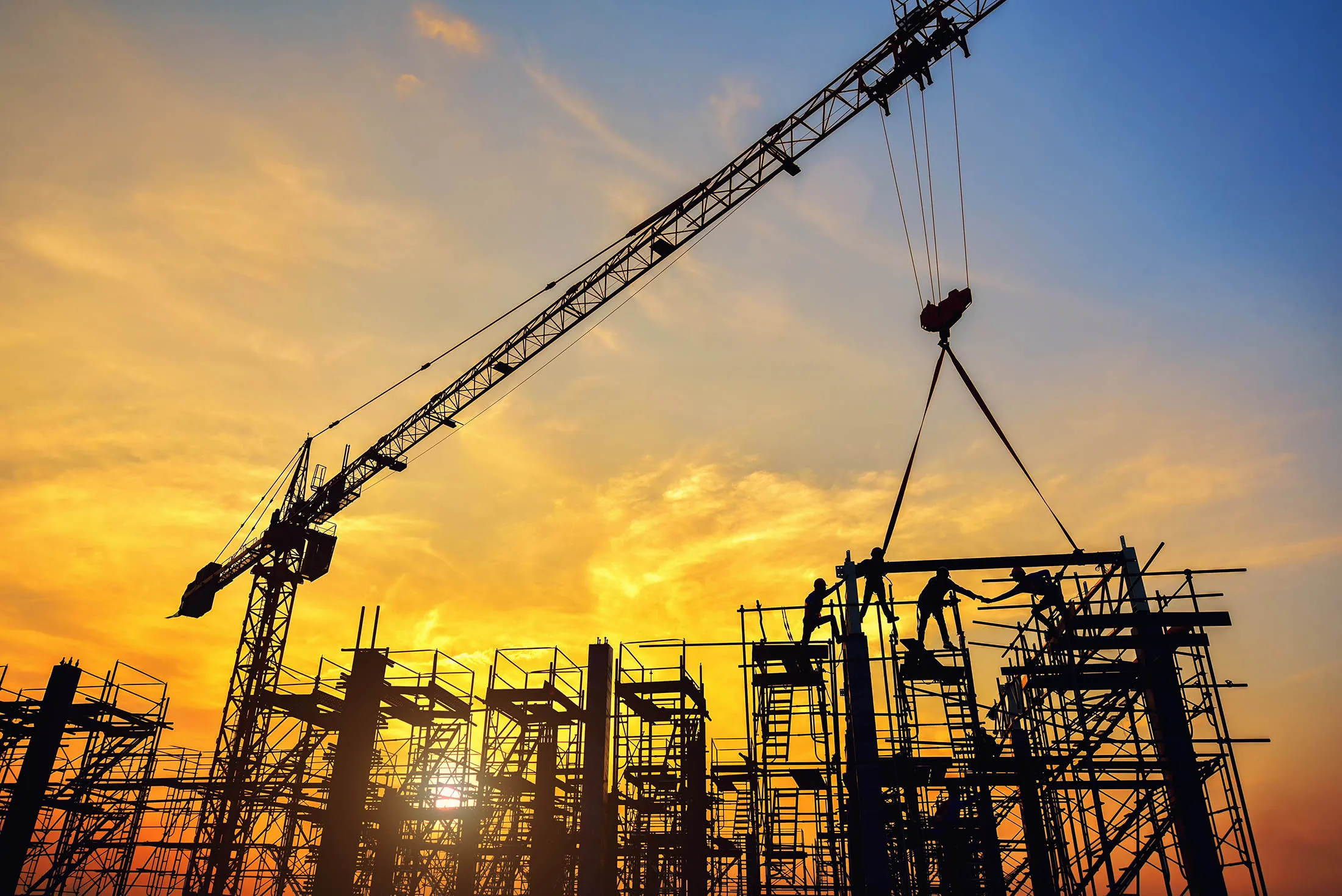 Silhouette of engineer and safety officer looking construction worker pouring a concrete column on scaffolding in construction  site