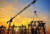 Silhouette of engineer and safety officer looking construction worker pouring a concrete column on scaffolding in construction  site