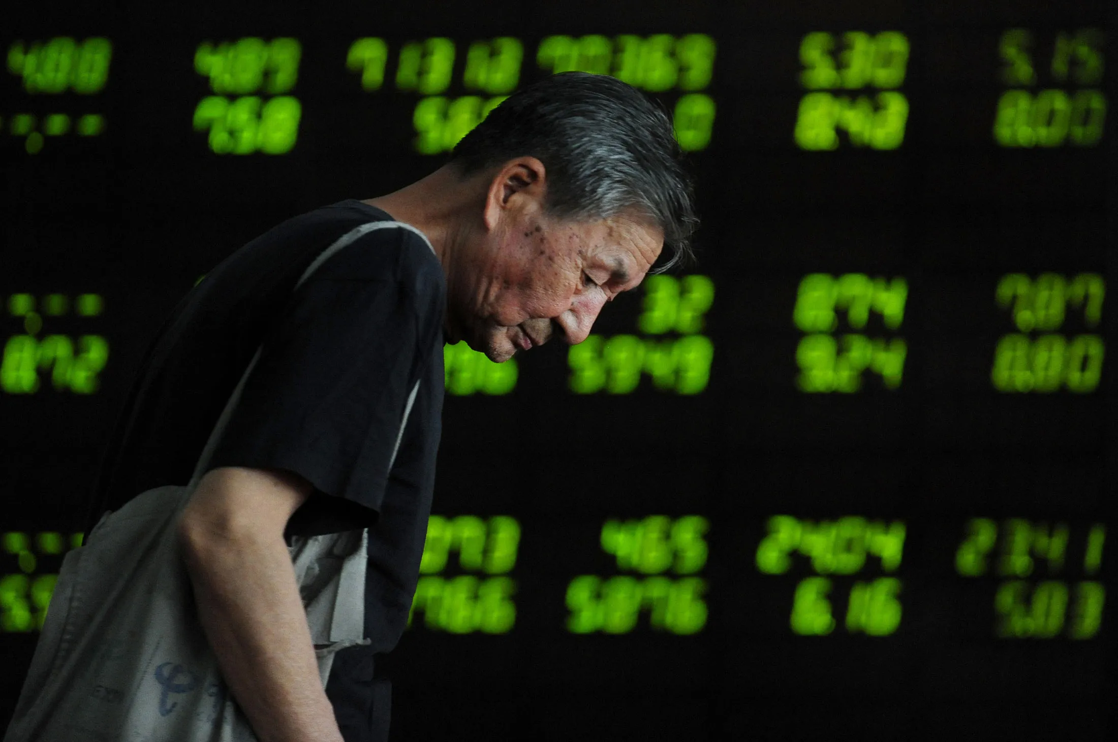 An investor observes electronic board at a stock exchange hall on July 7, 2015 in Shenyang, Liaoning Province of China.
