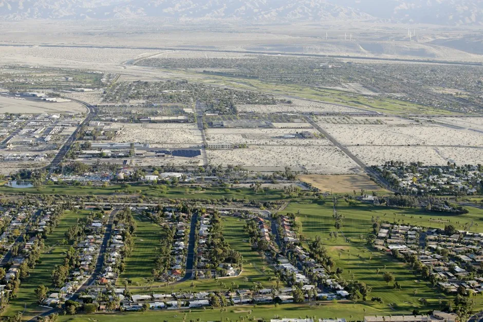 Lush green golf courses border the edge of the desert in Palm Springs, California.