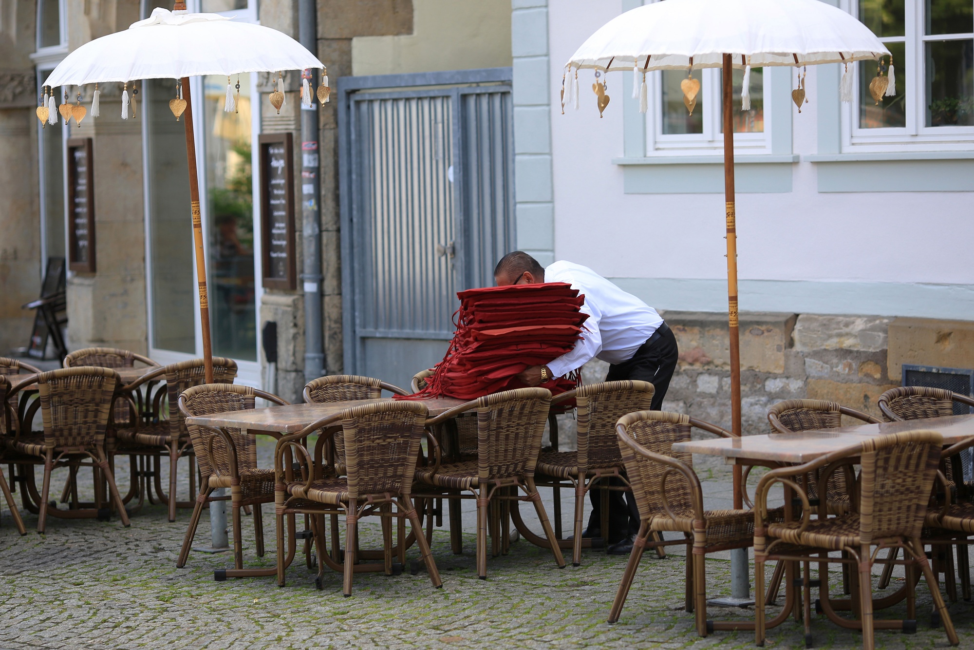 A waiter prepares table at a restaurant in the main city square in Erfurt, Germany.