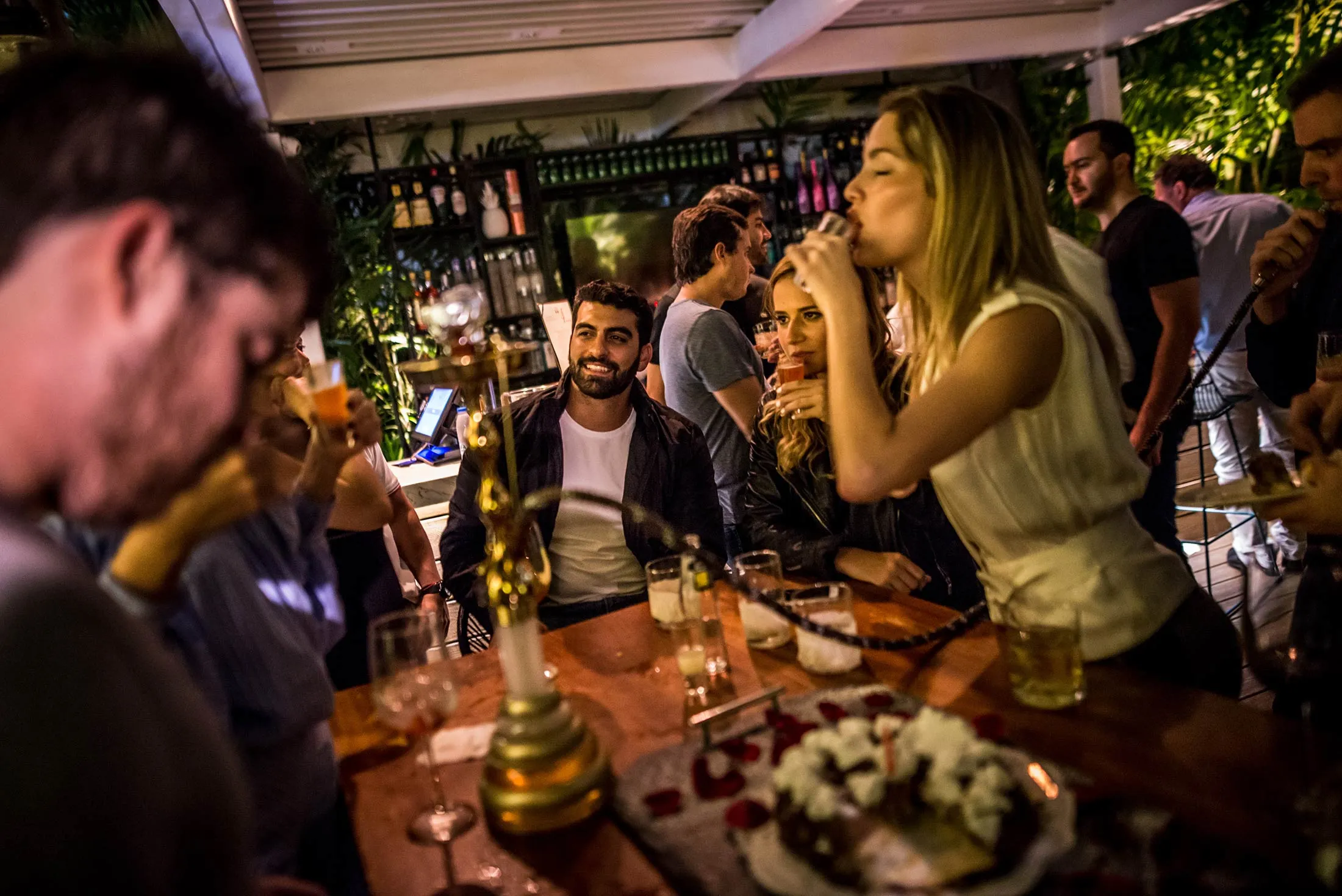 Alexandra Lovera (standing) takes a shot at the posh restaurant La Esquina, which is popular among high society, in Chacao&nbsp;on July 14, 2017.

